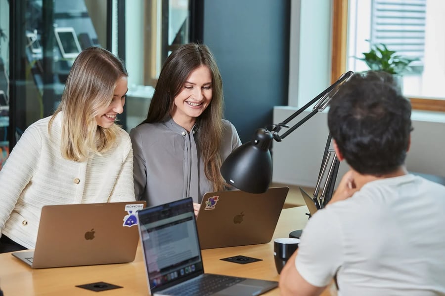 three people around one desk - Promon-SHIELD-support-coverage